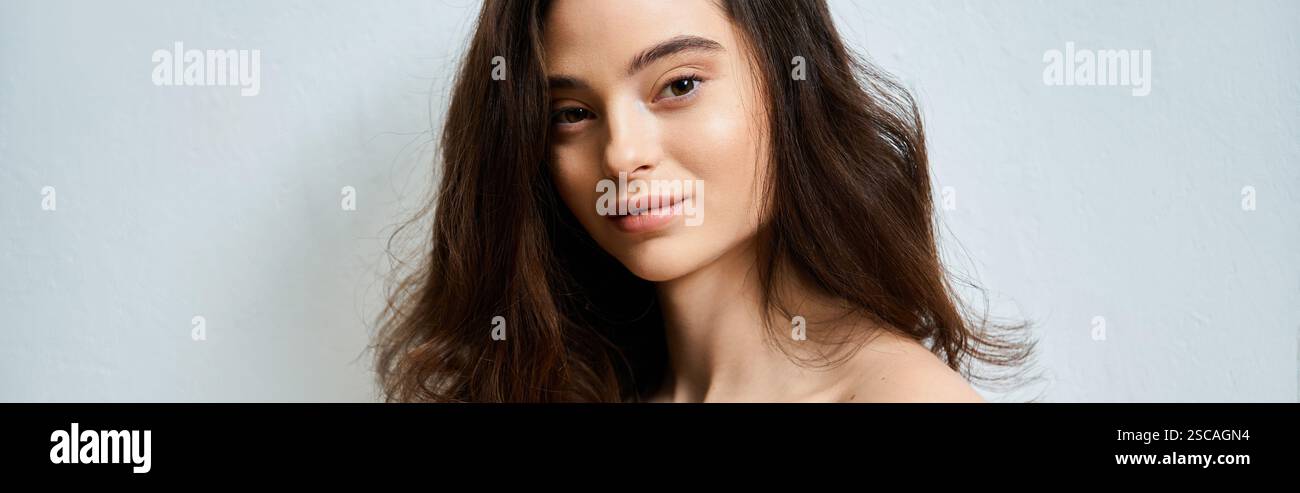 Une jeune femme gracieuse pose à l'intérieur, soulignant ses charmantes traits et son sourire radieux. Banque D'Images