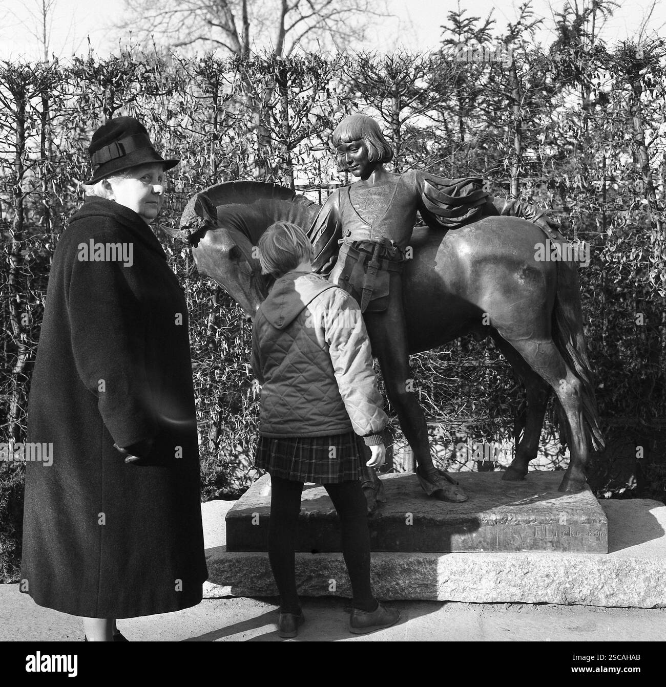 Tiergarten de Berlin : grand-mère avec manteau et chapeau et petite-fille, jetez un oeil à boy avec pony. Banque D'Images