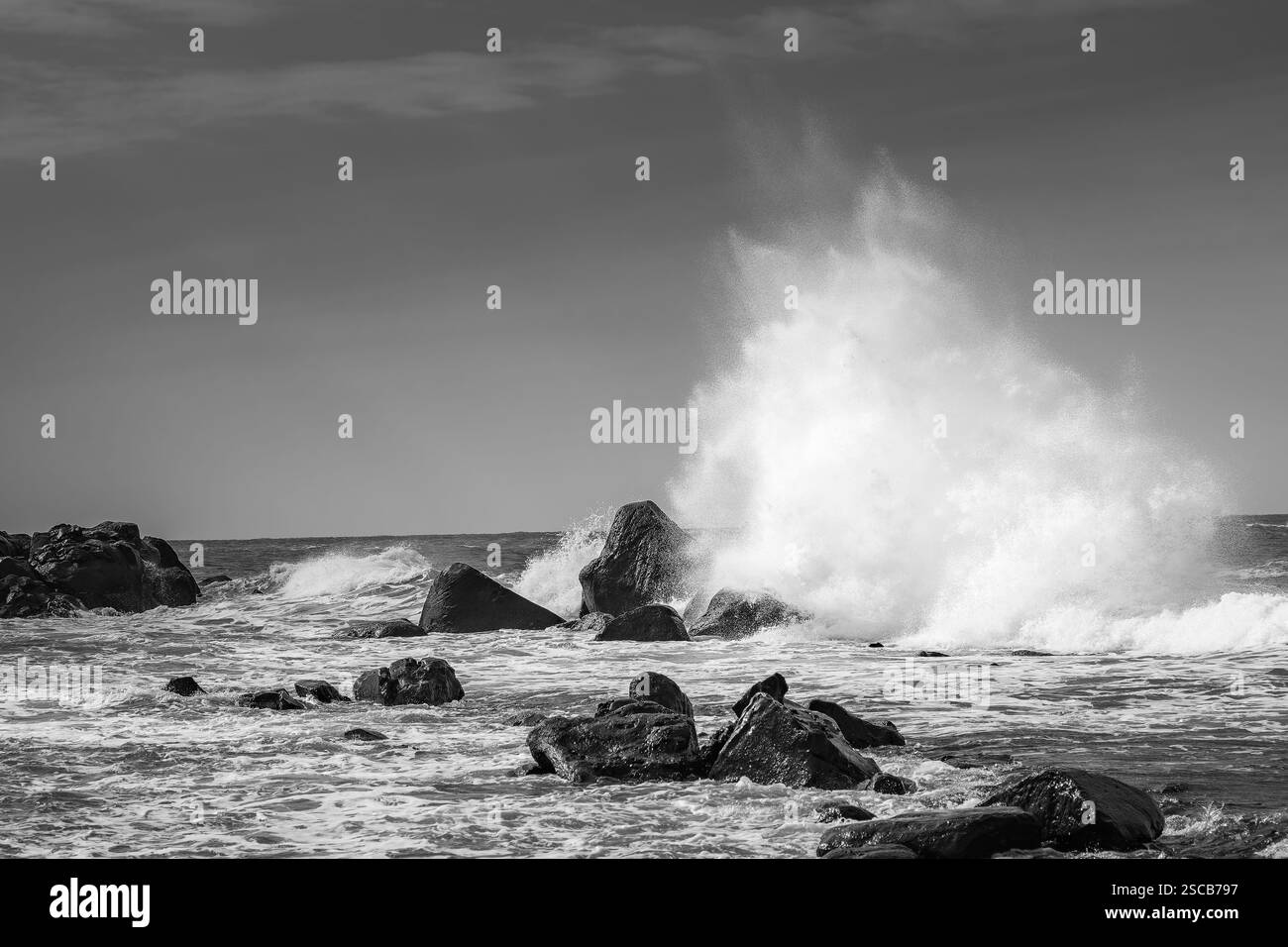 Vagues s'écrasant sur les rochers noir et blanc dramatique Banque D'Images