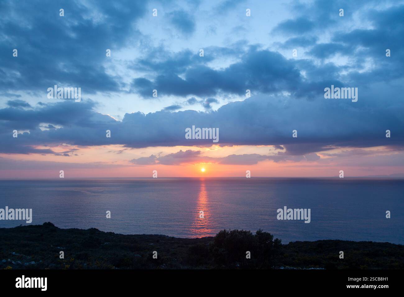 Un coucher de soleil à couper le souffle sur la mer Égée en Lakonia, Grèce. Le mélange parfait de couleurs, de nuages et de sérénité, capturant la beauté naturelle de Mani. Banque D'Images