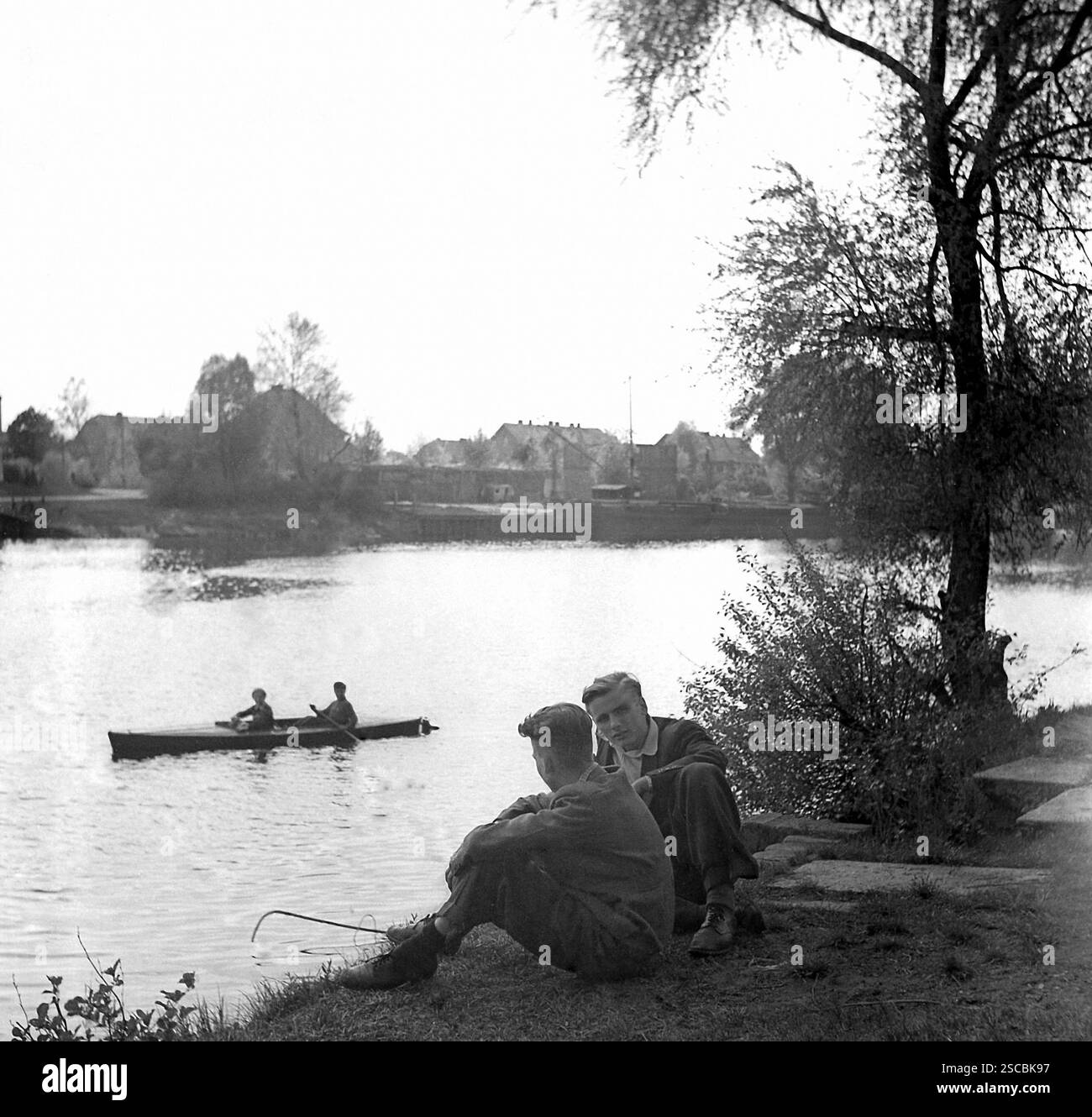 Les élèves assis à la rivière Spree à Fuerstenwalde. Dans le dos une chaloupe. Banque D'Images