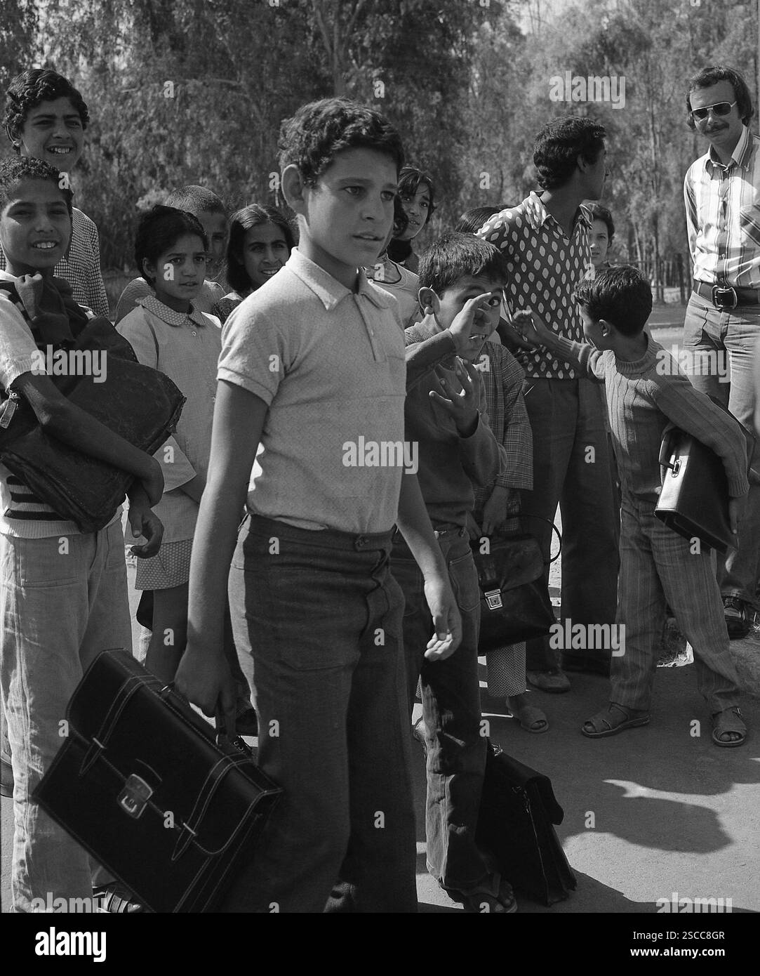 Les enfants avec des sacs à Sidi Kacem au Maroc. Banque D'Images