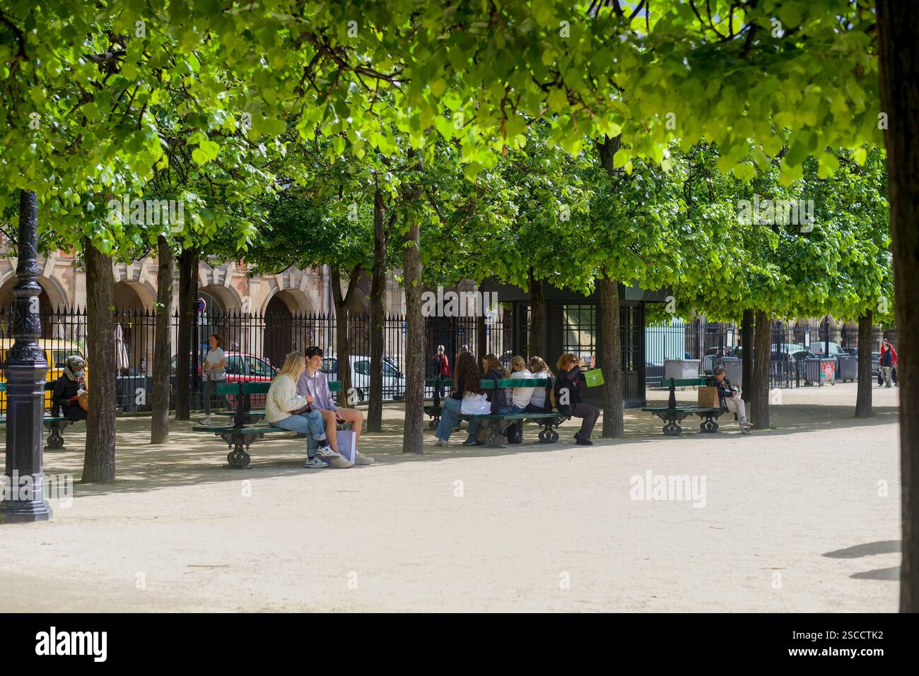 Les gens profitent d'une journée de printemps ensoleillée sur la place des Vosges. Place des Vosges dans la série Netflix 'Emily in Paris'. Emplacement du film Banque D'Images