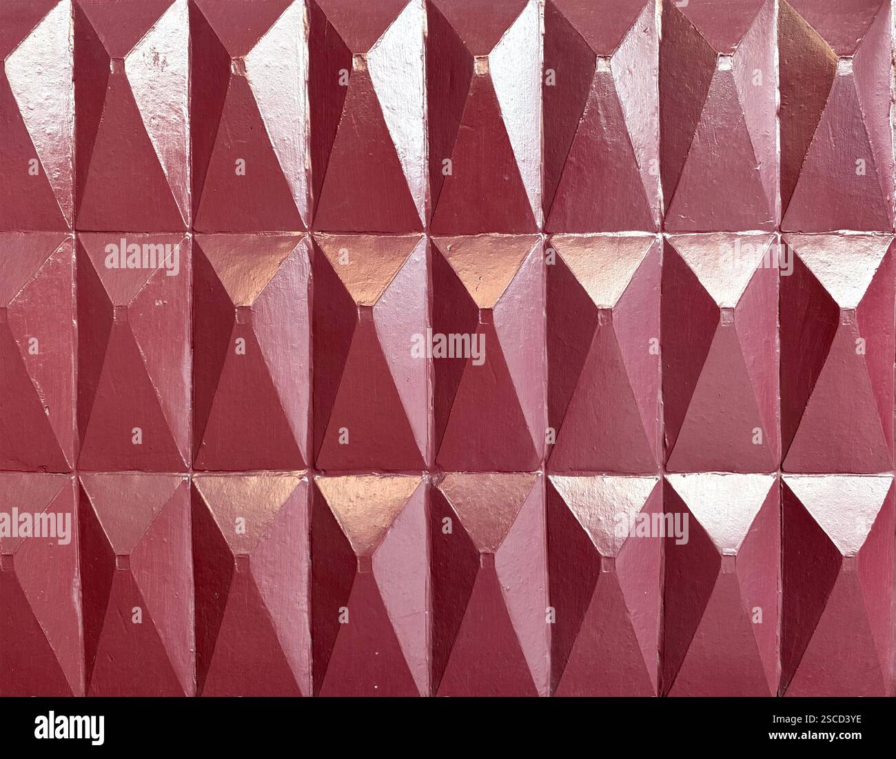 Tuiles 3D pyramidales et triangulaires sculptées en 3D en finition peinture rouge. Tuiles pyramidales 3D pour les finitions de panneaux muraux, texture de fond sans couture. Banque D'Images