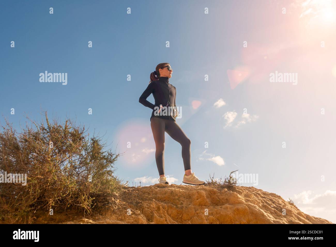 femme sportive debout au sommet d'une falaise profitant de la vue Banque D'Images femme sportive debout au sommet d'une falaise profitant de la vue Banque D'Images
