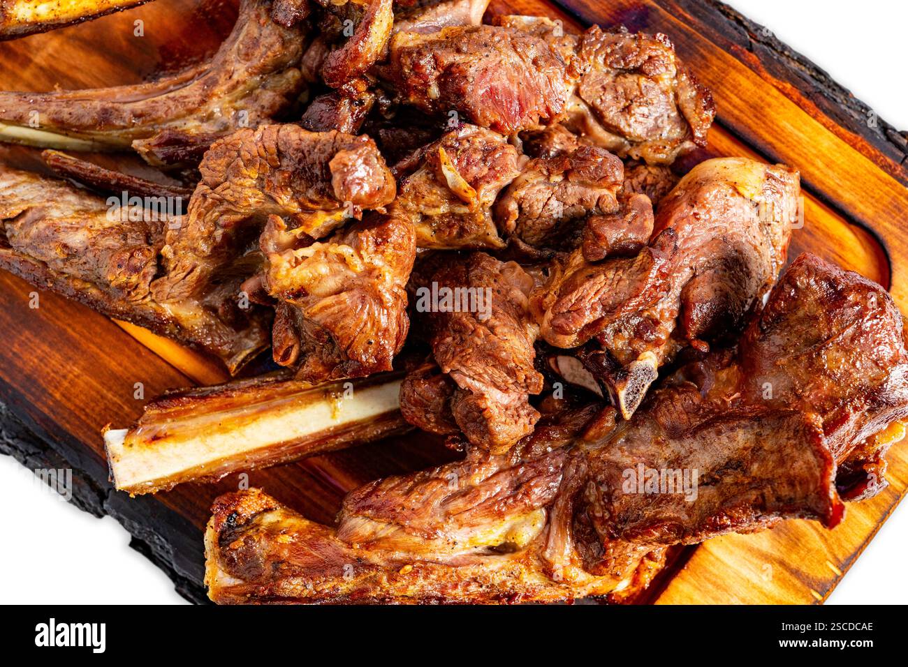 Des côtelettes d'agneau grillées juteuses reposent sur un plateau rustique en bois, présentant une alléchante présentation. L'atmosphère estivale vibrante améliore le plaisir Banque D'Images
