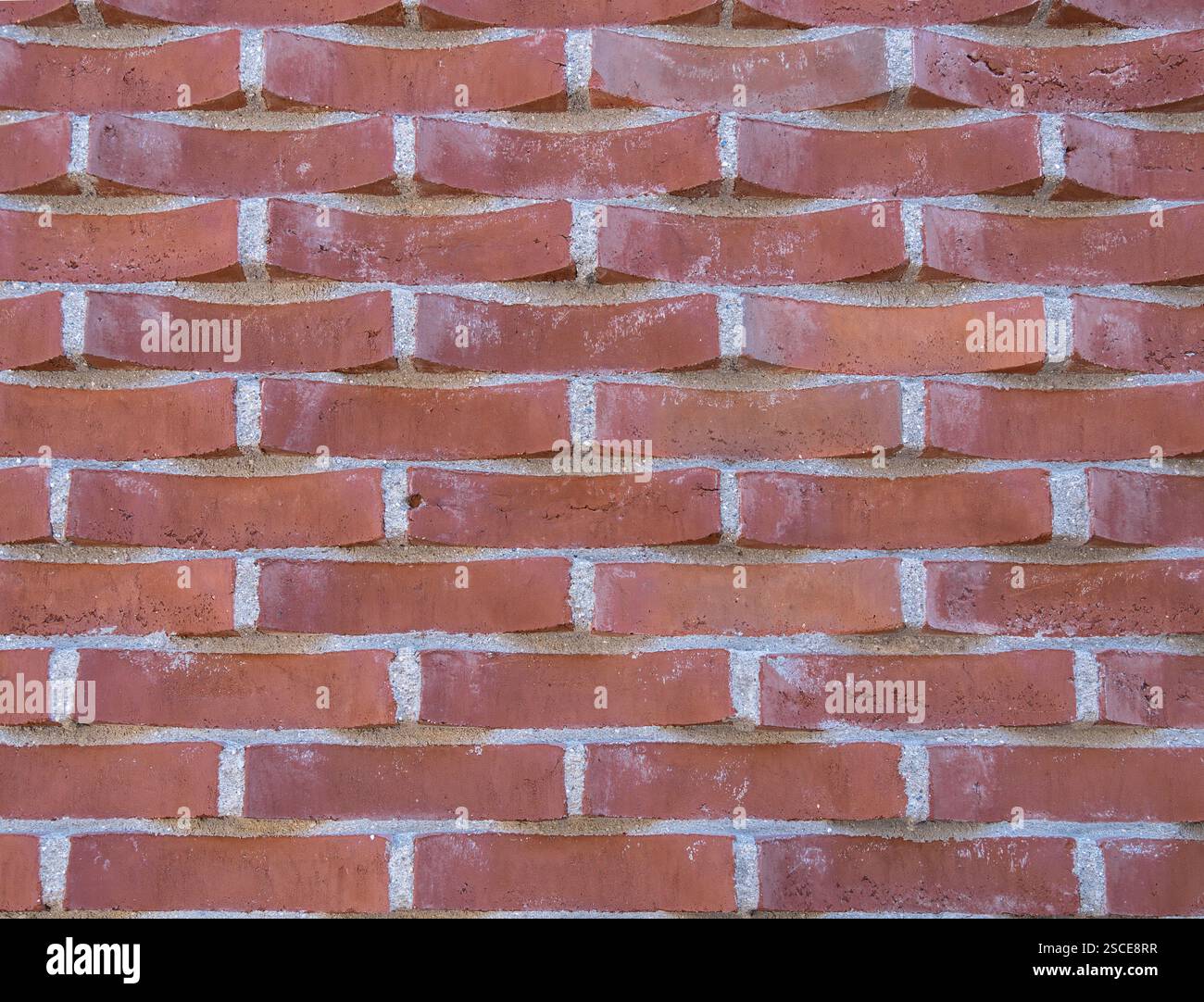 Un mur de briques à motifs uniques avec des briques inclinées, créant un effet de vague dynamique. Banque D'Images