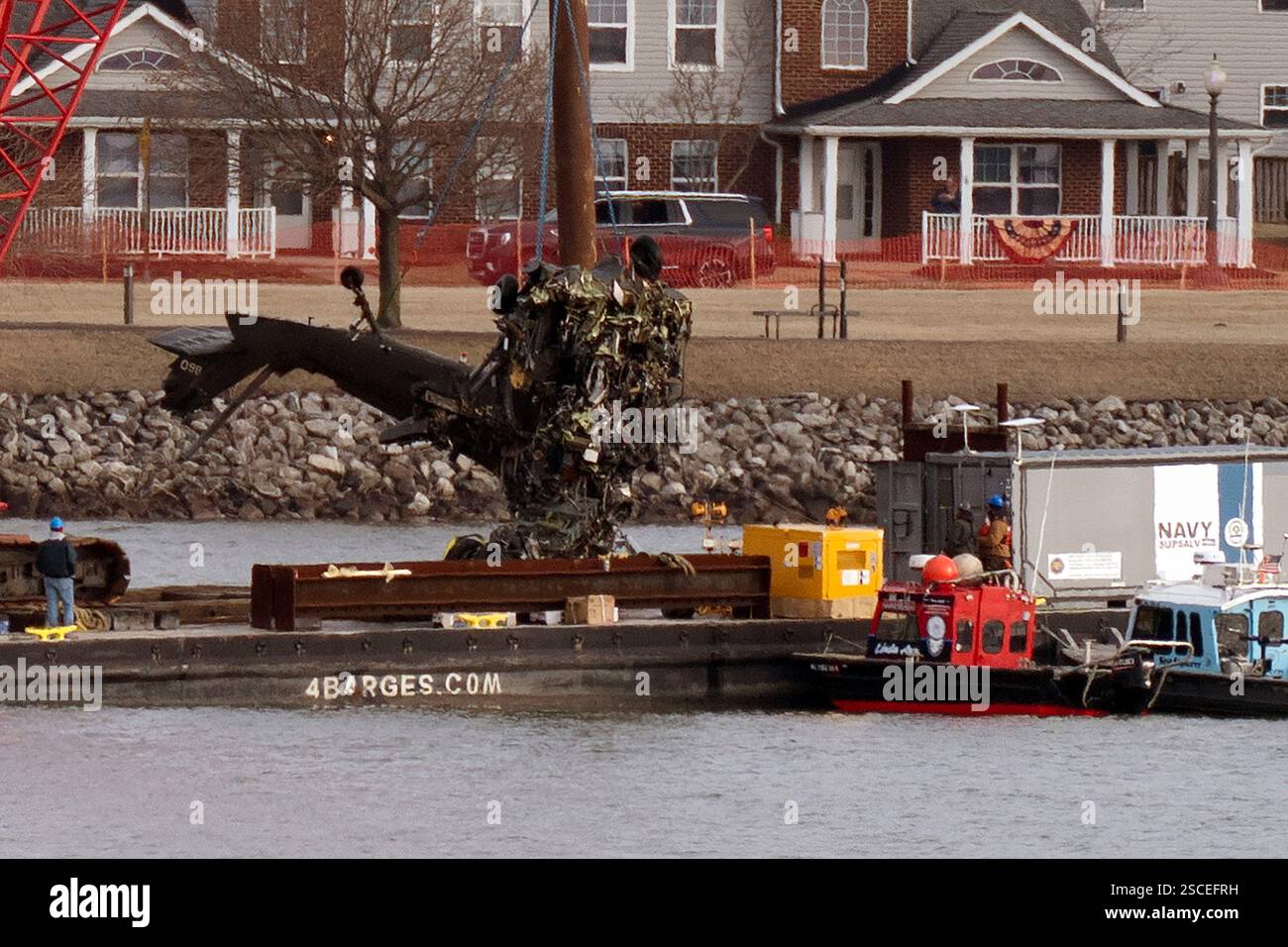 Rescue and salvage crews pull up a part of a Army Black Hawk helicopter ...