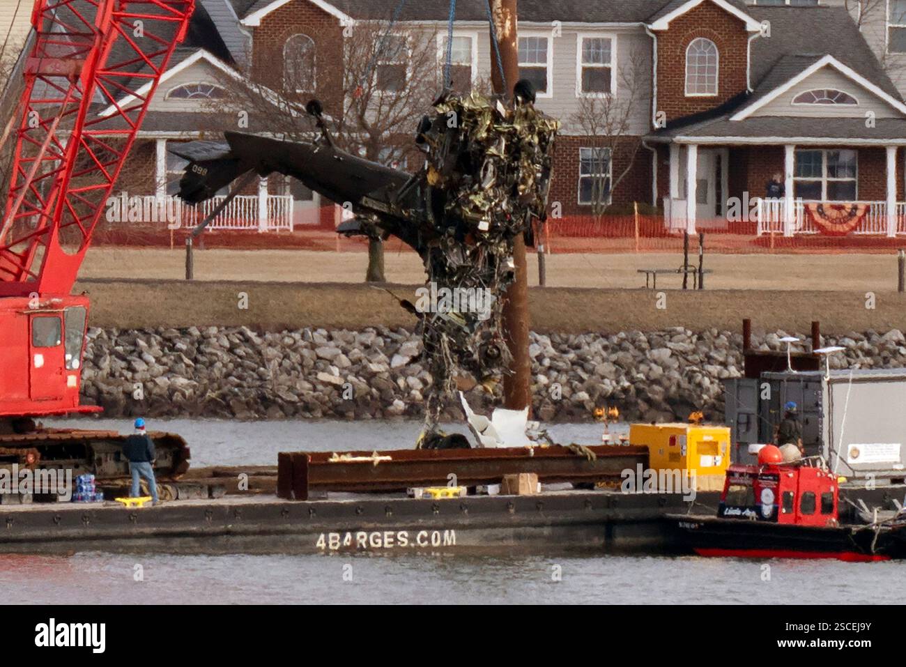 Salvage crews pull up a part of a Black Hawk helicopter near the site ...
