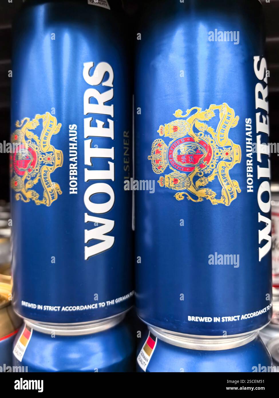 Bobruisk, Biélorussie - 4 février 2025 : deux grandes canettes de bière aux motifs complexes sont empilées dans une allée de magasin, mettant en valeur leur captivante couleur bleue A. Banque D'Images