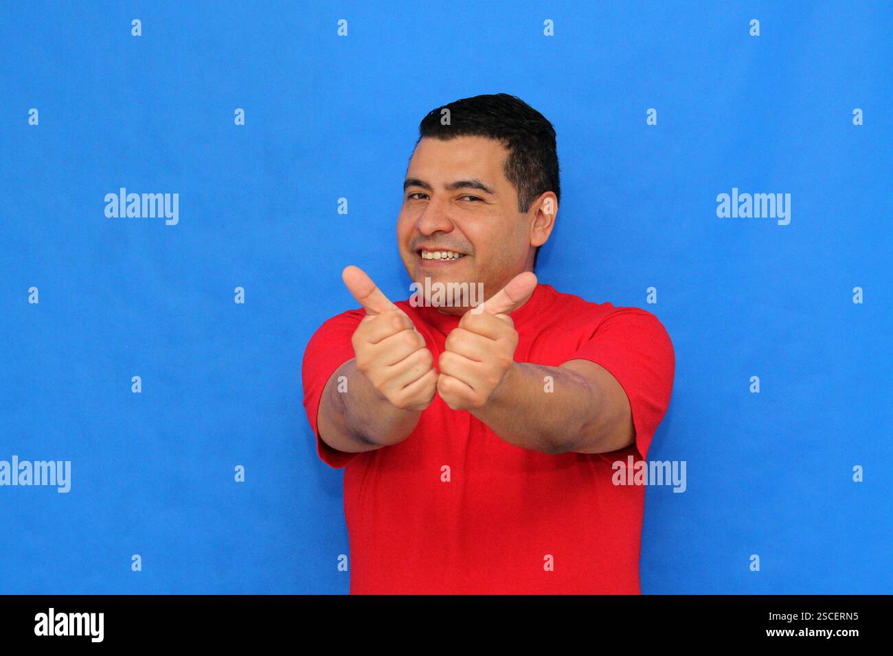 Homme adulte latino-peau foncée montre le signe OK ou approuvé avec sa main enthousiaste et positive Banque D'Images Homme adulte latino-peau foncée montre le signe OK ou approuvé avec sa main enthousiaste et positive Banque D'Images