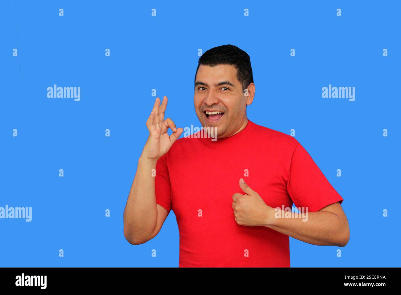Homme adulte latino-peau foncée montre le signe OK ou approuvé avec sa main enthousiaste et positive Banque D'Images Homme adulte latino-peau foncée montre le signe OK ou approuvé avec sa main enthousiaste et positive Banque D'Images