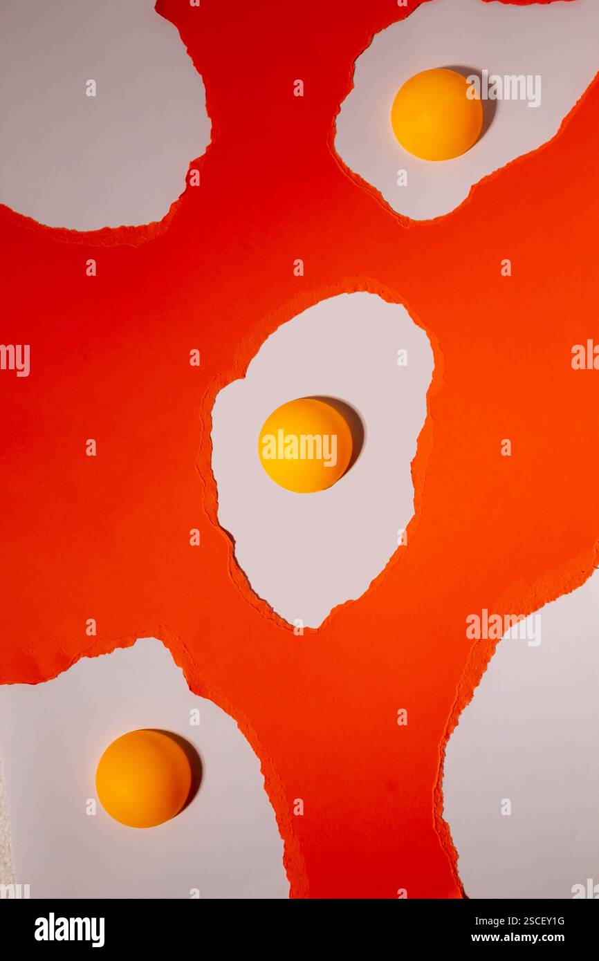 Oeufs faits de papier déchiré orange sur fond blanc avec des boules de ping-pong. Motif créatif abstrait Banque D'Images