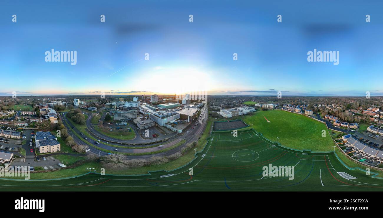 Ville au coucher du soleil avec un champ vert au premier plan Banque D'Images