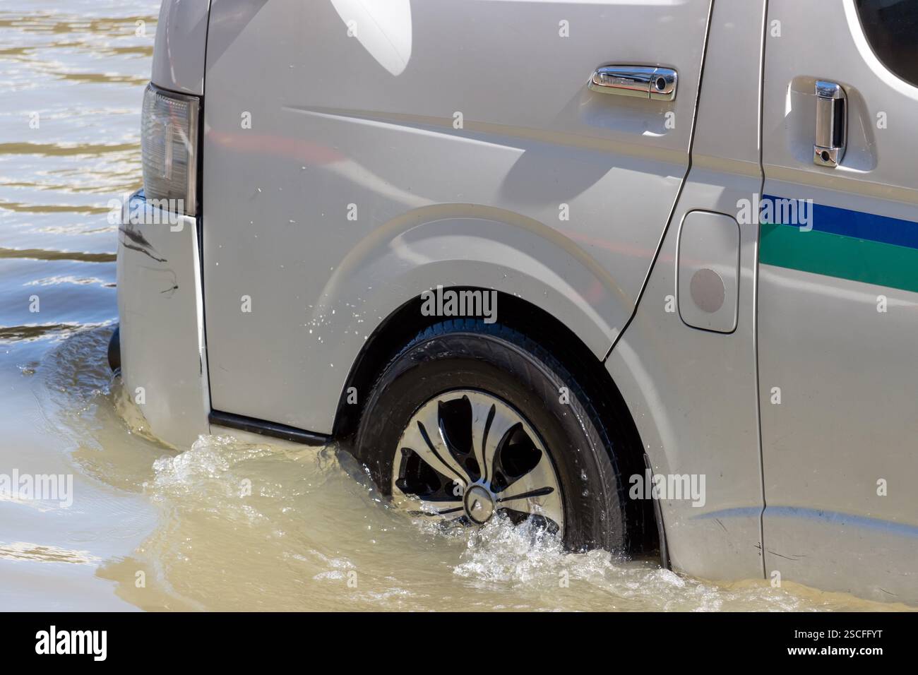 Un minibus traverse une rue inondée de la ville Banque D'Images