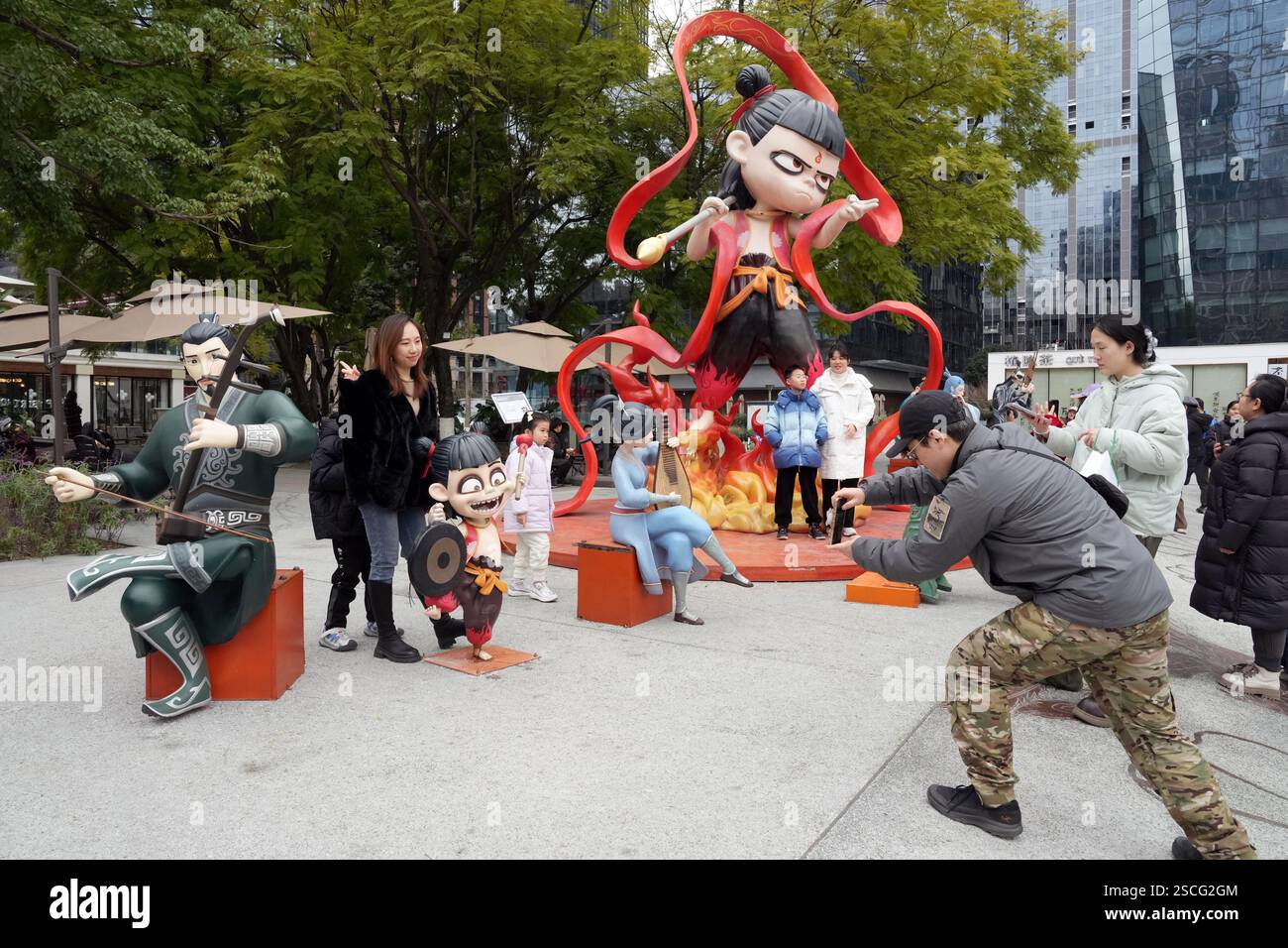 Chengdu, China.6th février 2025. Un visiteur pose pour une photo avec une sculpture de ne Zha, une figure mythologique chinoise, sur l'avenue Jiaozi le 6 février 2025 à Chengdu, province chinoise du Sichuan. Le film d'animation ne Zha 2 a surpassé l'épopée de guerre de 2021 « la bataille au lac Changjin » pour devenir le film le plus rentable de tous les temps en Chine. Crédit : an Yuan/China News Service/Alamy Live News Banque D'Images