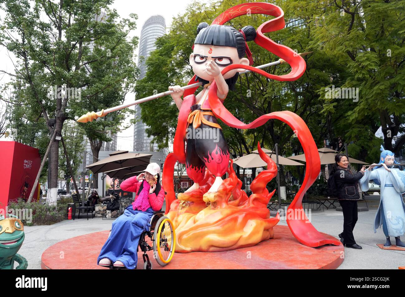 Chengdu, China.6th février 2025. Un visiteur pose pour une photo avec une sculpture de ne Zha, une figure mythologique chinoise, sur l'avenue Jiaozi le 6 février 2025 à Chengdu, province chinoise du Sichuan. Le film d'animation ne Zha 2 a surpassé l'épopée de guerre de 2021 « la bataille au lac Changjin » pour devenir le film le plus rentable de tous les temps en Chine. Crédit : an Yuan/China News Service/Alamy Live News Banque D'Images