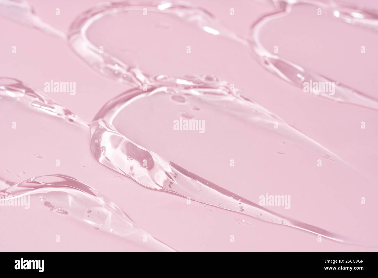 Gel transparent taches taches nuances textures sur fond rose Banque D'Images