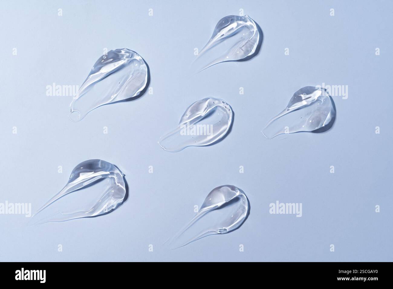 Gel de soins de la peau, sérum de visage, frottis sur fond bleu. Produit cosmétique de beauté gelée transparente et légère, mouiller en gros plan Banque D'Images