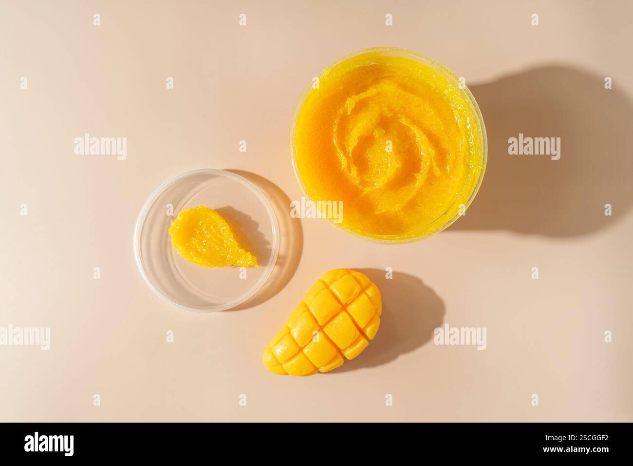 Un savon naturel de mangue de soin du corps et une tache cosmétique jaune pour les procédures de spa debout sur un fond beige Banque D'Images