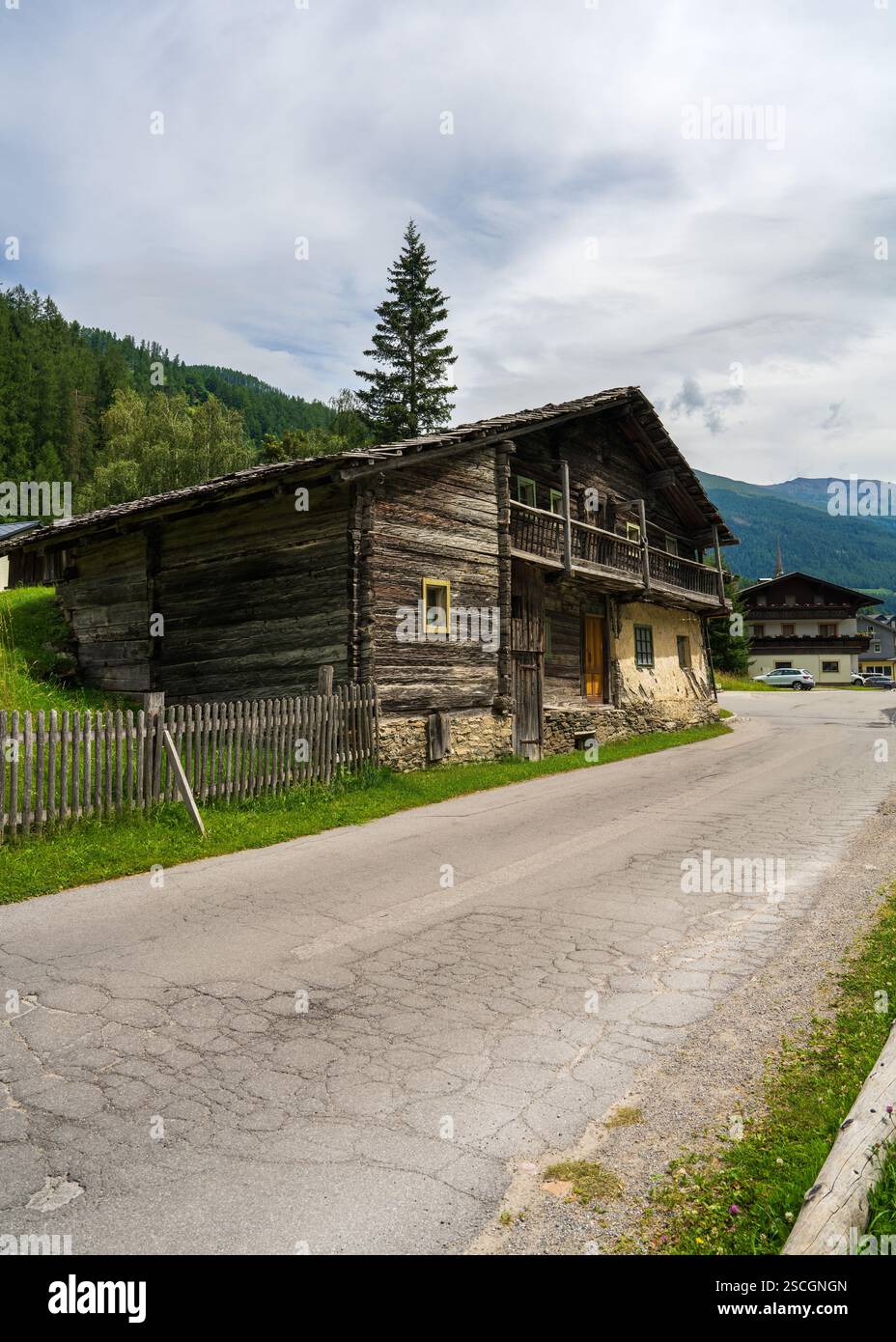 Authentique ancienne maison en bois entourée de verdoyantes prairies alpines, montagnes majestueuses. Autriche, Heiligenblut. Concept : vie à la campagne, paysage de montagne Banque D'Images