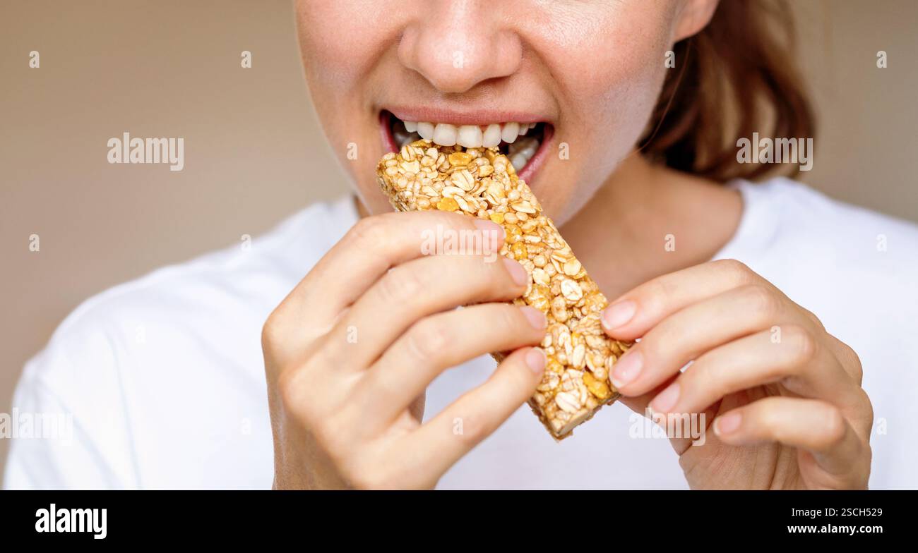 Femme mangeant de la barre protéinée. Alimentation saine. Banque D'Images
