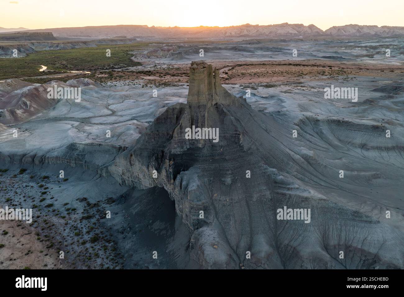 Une vue aérienne panoramique capture le vaste terrain érodé du désert de l'Utah au coucher du soleil, mettant en évidence les formations géologiques complexes et la décoloration douce Banque D'Images