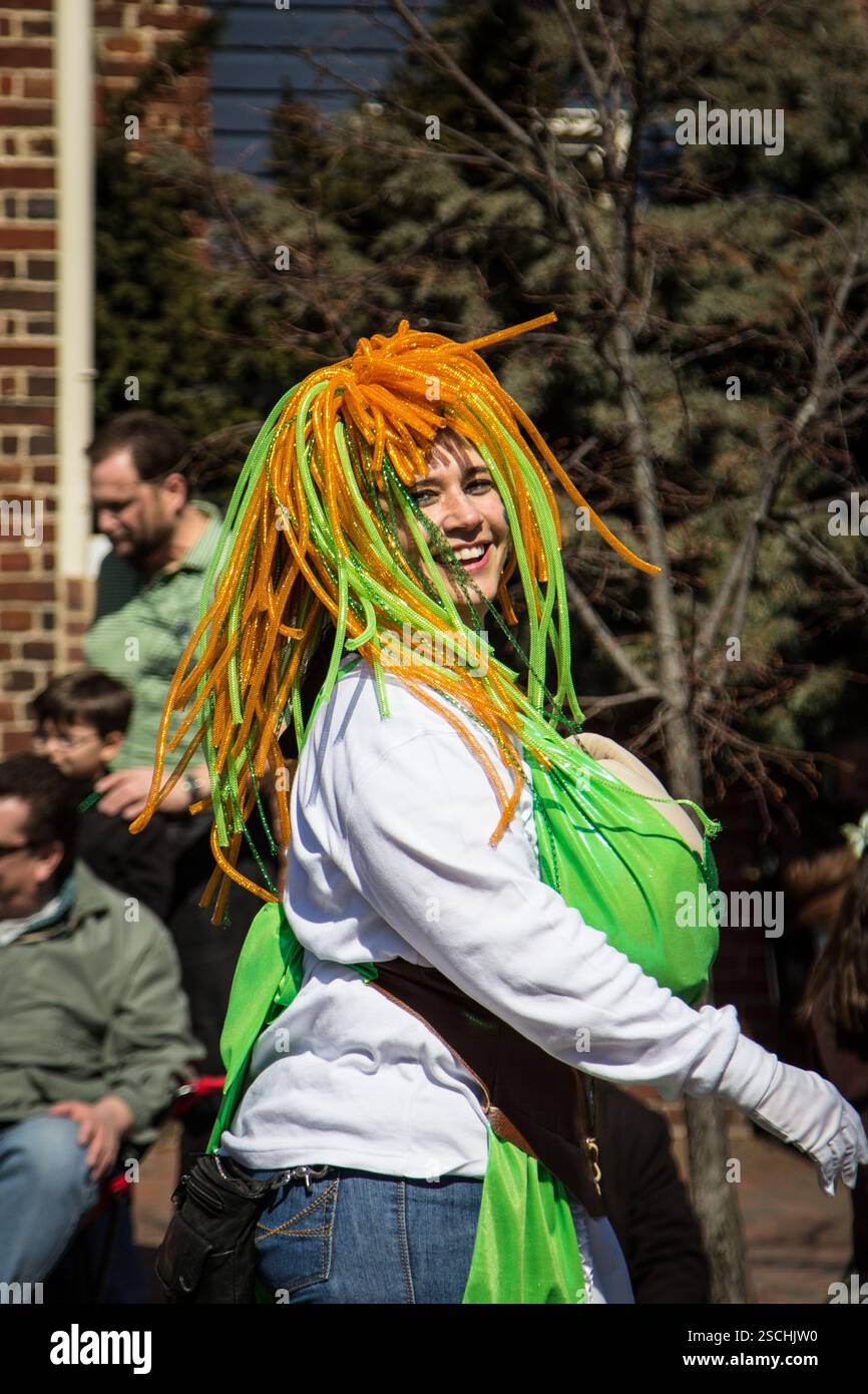 Femme dans. Défilé de la fête de Patrick, cheveux orange/vert éclatants, costume vert. Amusant, festif. Banque D'Images