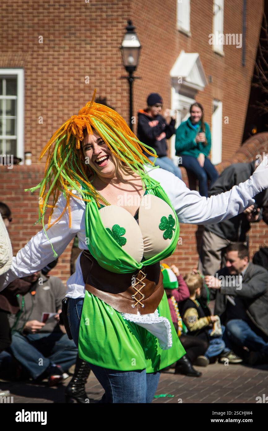Défilé de la fête de Patrick. Femme en costume élaboré, souriant et ondulant. Banque D'Images