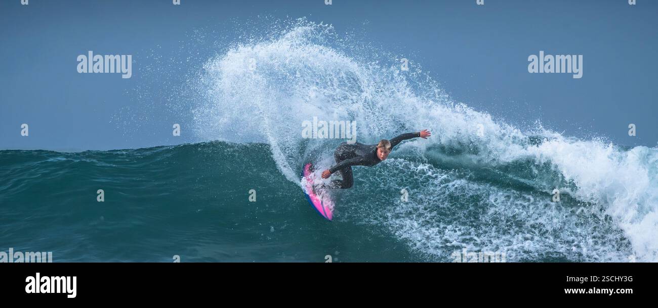 Image panoramique d'un surfeur qui fait une vague à Fistral à Newquay, en Cornouailles, au Royaume-Uni. Banque D'Images