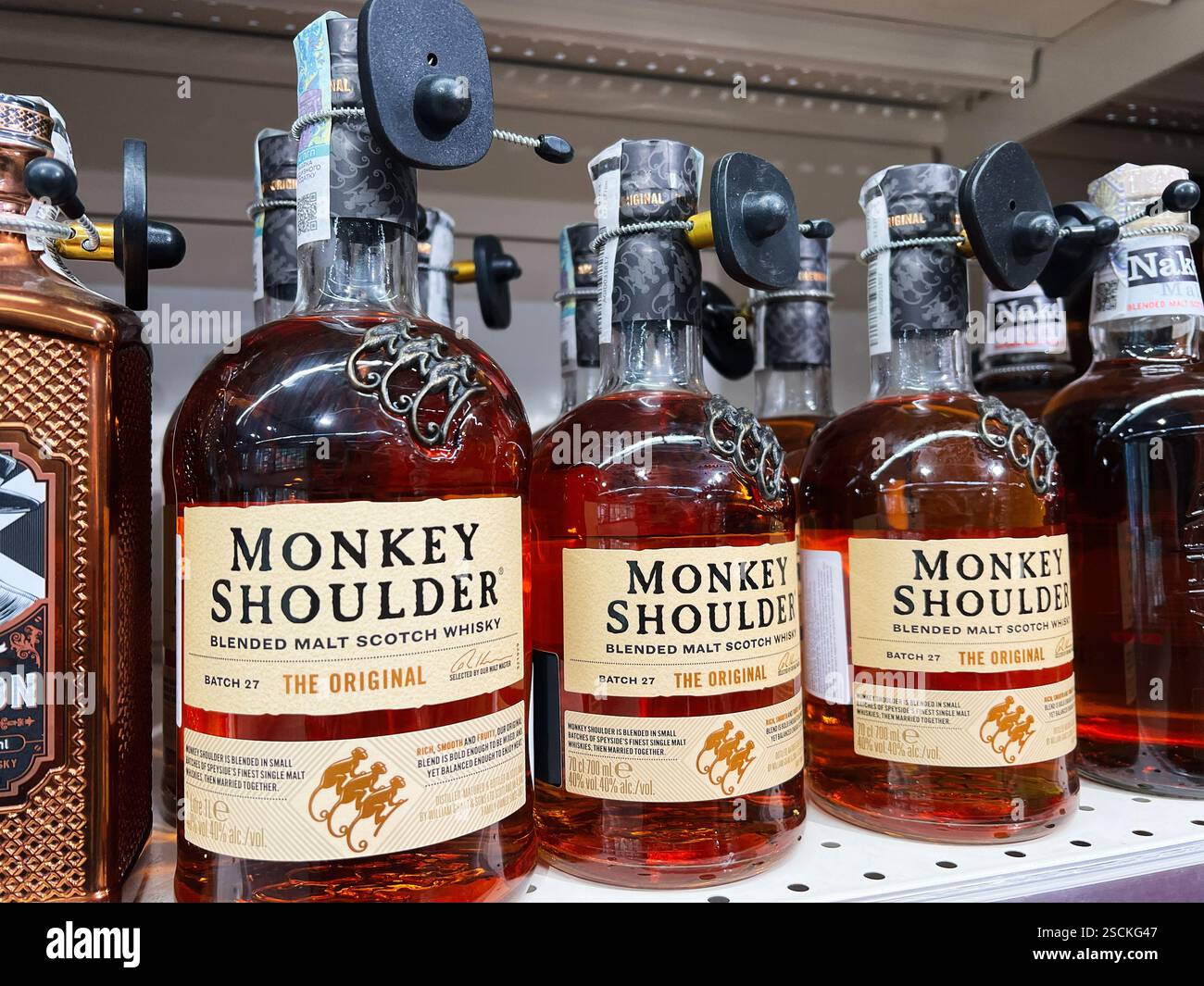 Kiev, Ukraine - 04 février 2025 : gros plan de bouteilles de whisky Monkey Shoulder disposées soigneusement sur une étagère de magasin d'alcool Banque D'Images