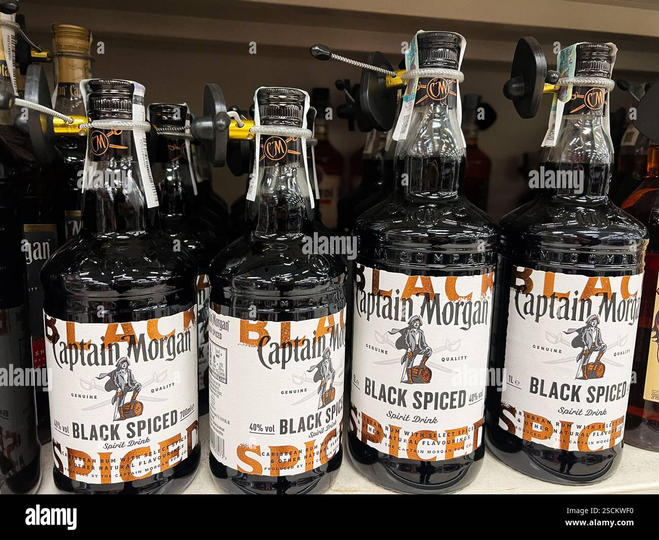 Kiev, Ukraine - 04 février 2025 : bouteilles de rhum Capitaine Morgan épicées disposées ensemble sur une étagère de magasin avec des verrous de sécurité attachés. Banque D'Images
