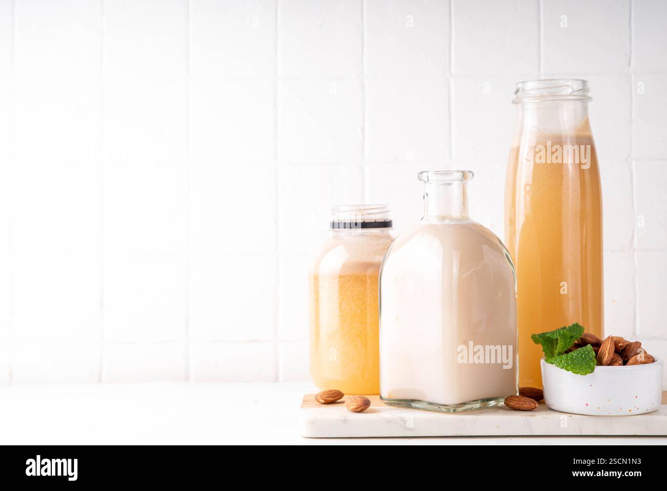 Sirop d'orgeat d'amande maison dans différentes bouteilles, amandes, eau, sucre et sirop d'eau de fleur d'oranger pour faire des cocktails sucrés Banque D'Images
