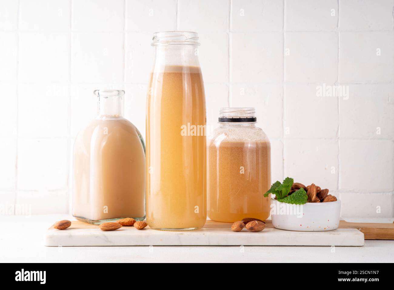 Sirop d'orgeat d'amande maison dans différentes bouteilles, amandes, eau, sucre et sirop d'eau de fleur d'oranger pour faire des cocktails sucrés Banque D'Images