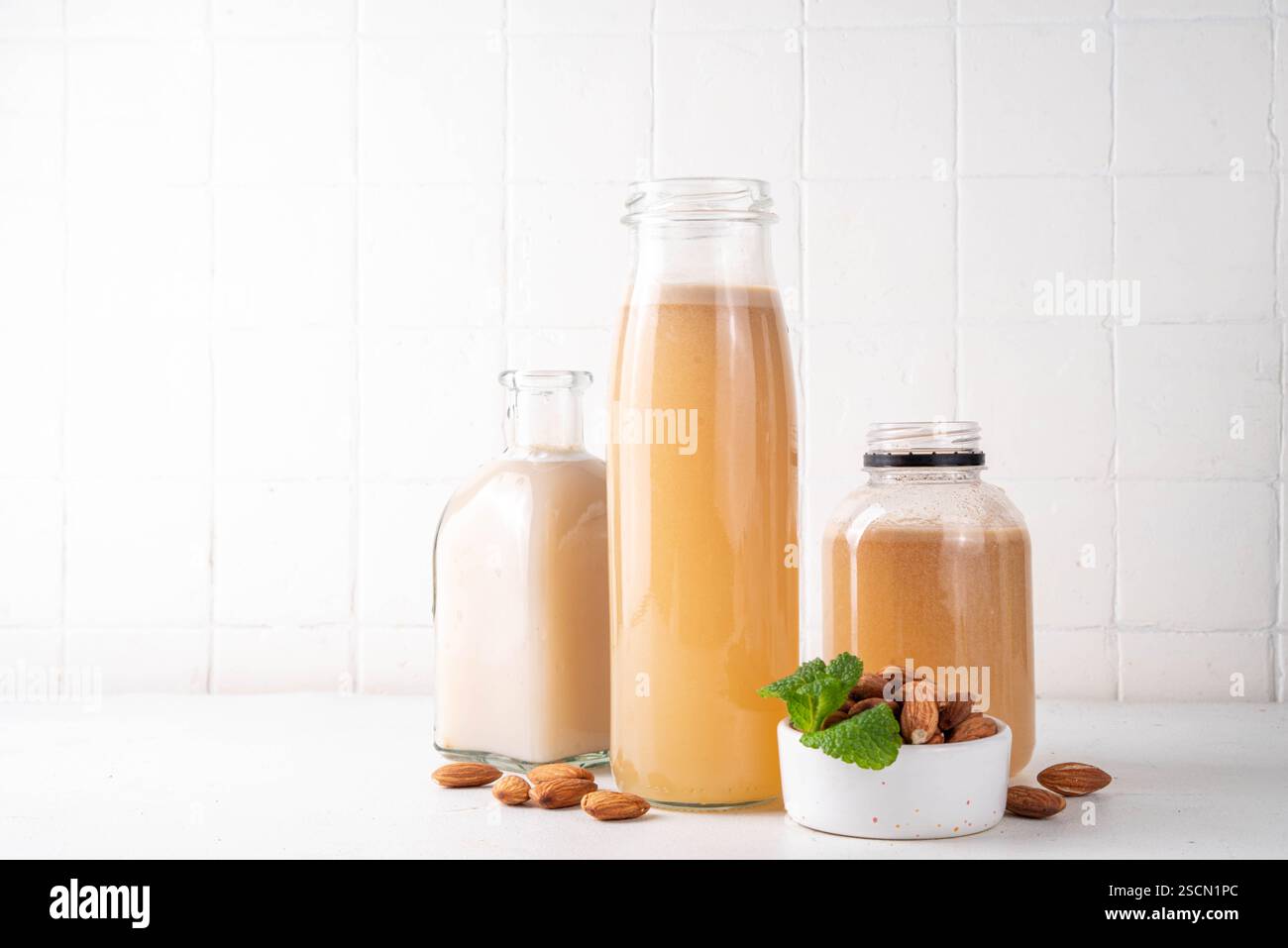 Sirop d'orgeat d'amande maison dans différentes bouteilles, amandes, eau, sucre et sirop d'eau de fleur d'oranger pour faire des cocktails sucrés Banque D'Images