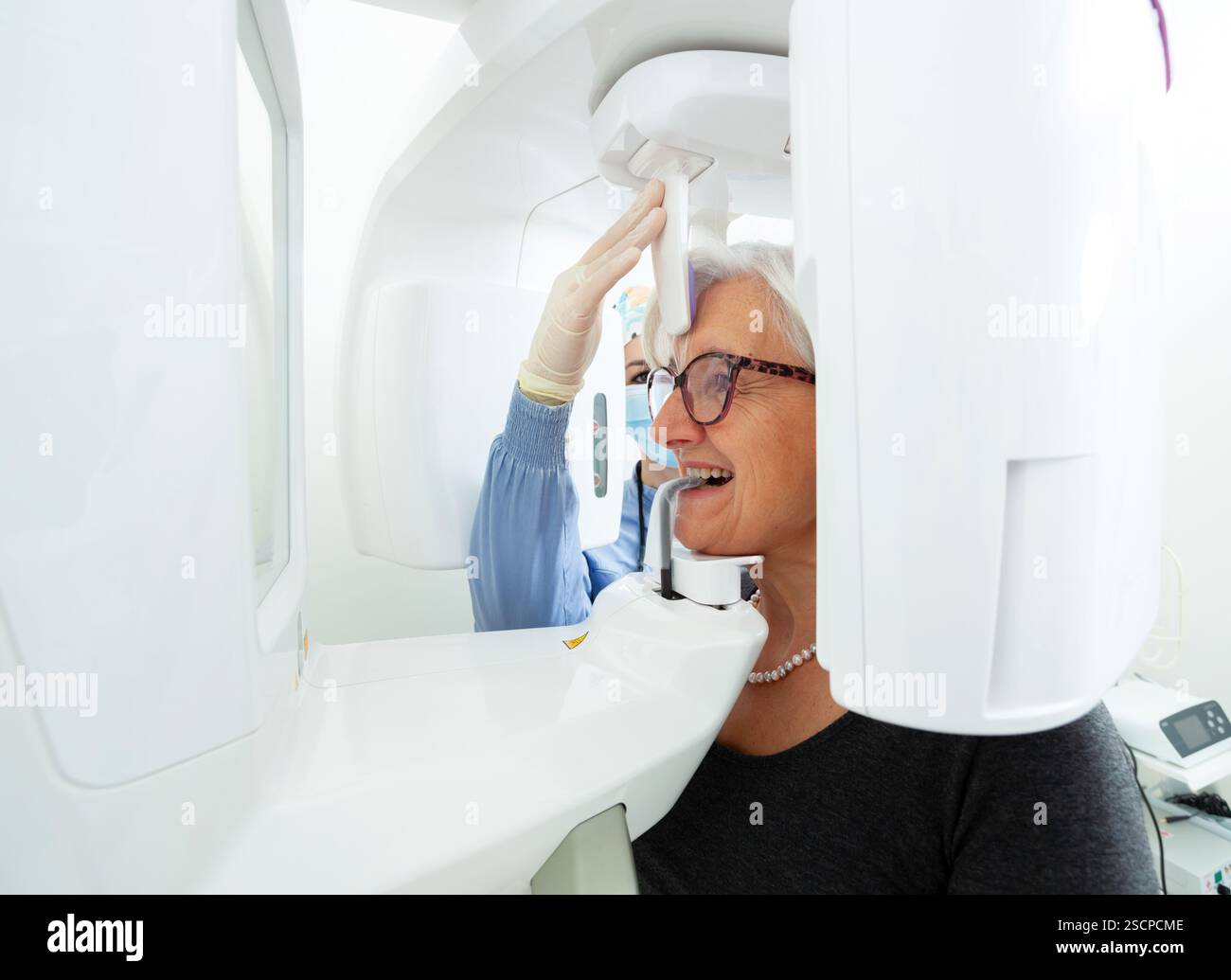 Appareillage de réglage du dentiste pour une radiographie panoramique dentaire de femme âgée dans une clinique dentaire moderne Banque D'Images