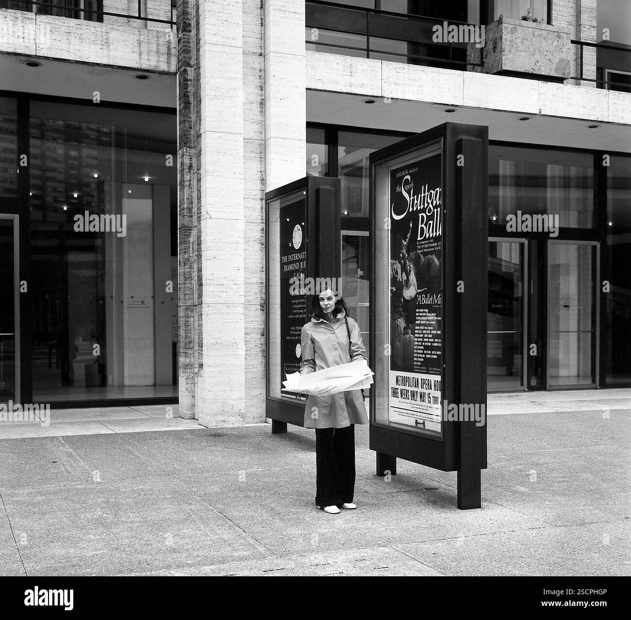 Une jeune femme avec un plan de la ville à la main devant le Lincoln Center et le Metropolitan Opera de New York. [traduction automatique] Banque D'Images