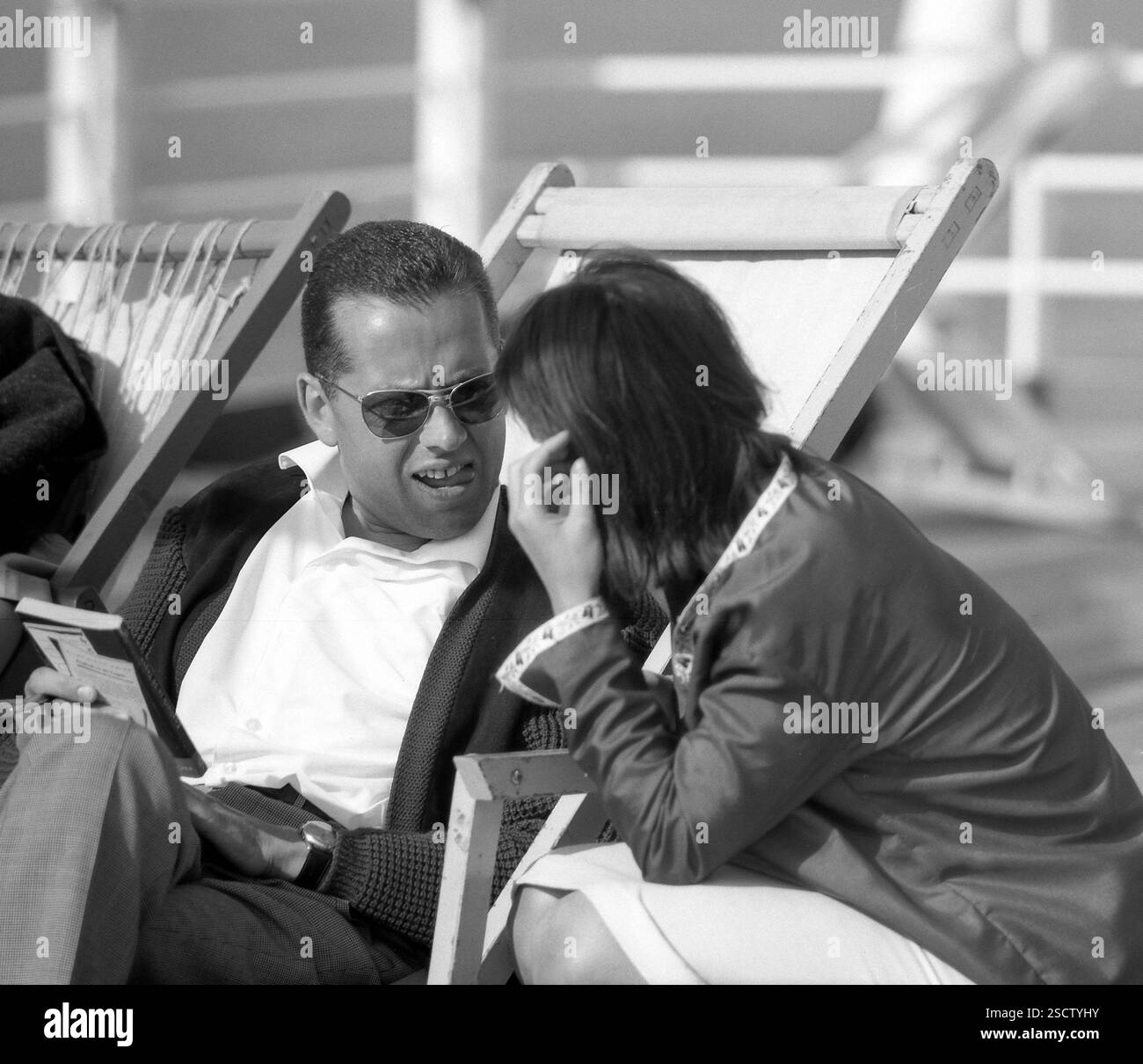 Bateau de croisière 'Statendam' sur l'Atlantique : l'image montre un homme avec un livre et des lunettes de soleil parlant à une femme. [traduction automatique] Banque D'Images