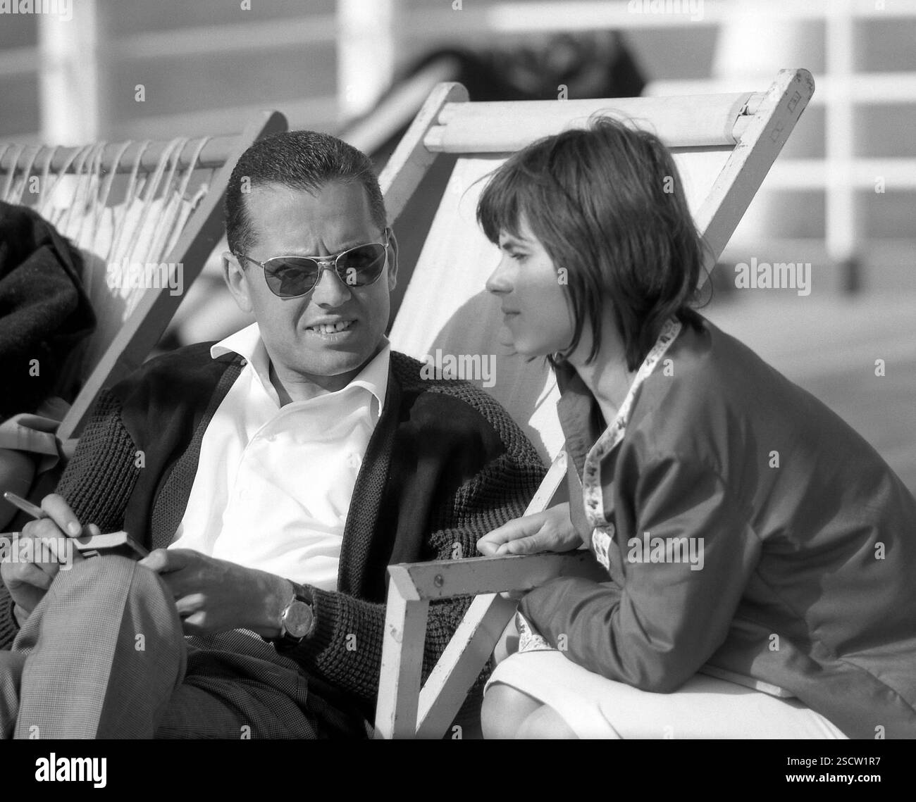 Bateau de croisière 'Statendam' sur l'Atlantique : l'image montre un homme avec un livre et des lunettes de soleil parlant à une femme. [traduction automatique] Banque D'Images