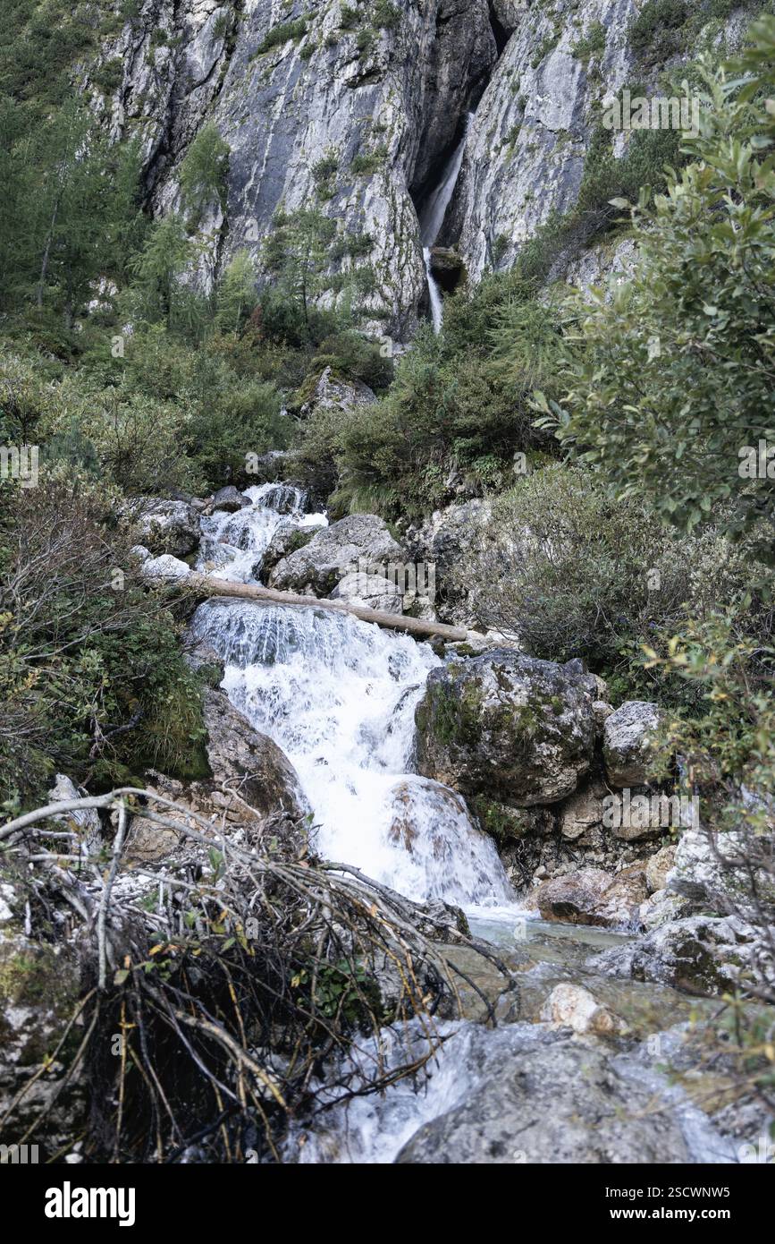 Une vue verticale des cascades de Pisciadu dans les Dolomites avec de l'eau précipitée, des falaises rocheuses, une végétation alpine et la beauté naturelle des montagnes Banque D'Images