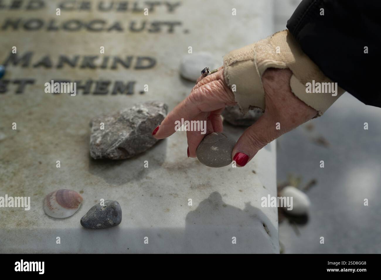 Personne place une pierre sur un mémorial de l'Holocauste Banque D'Images