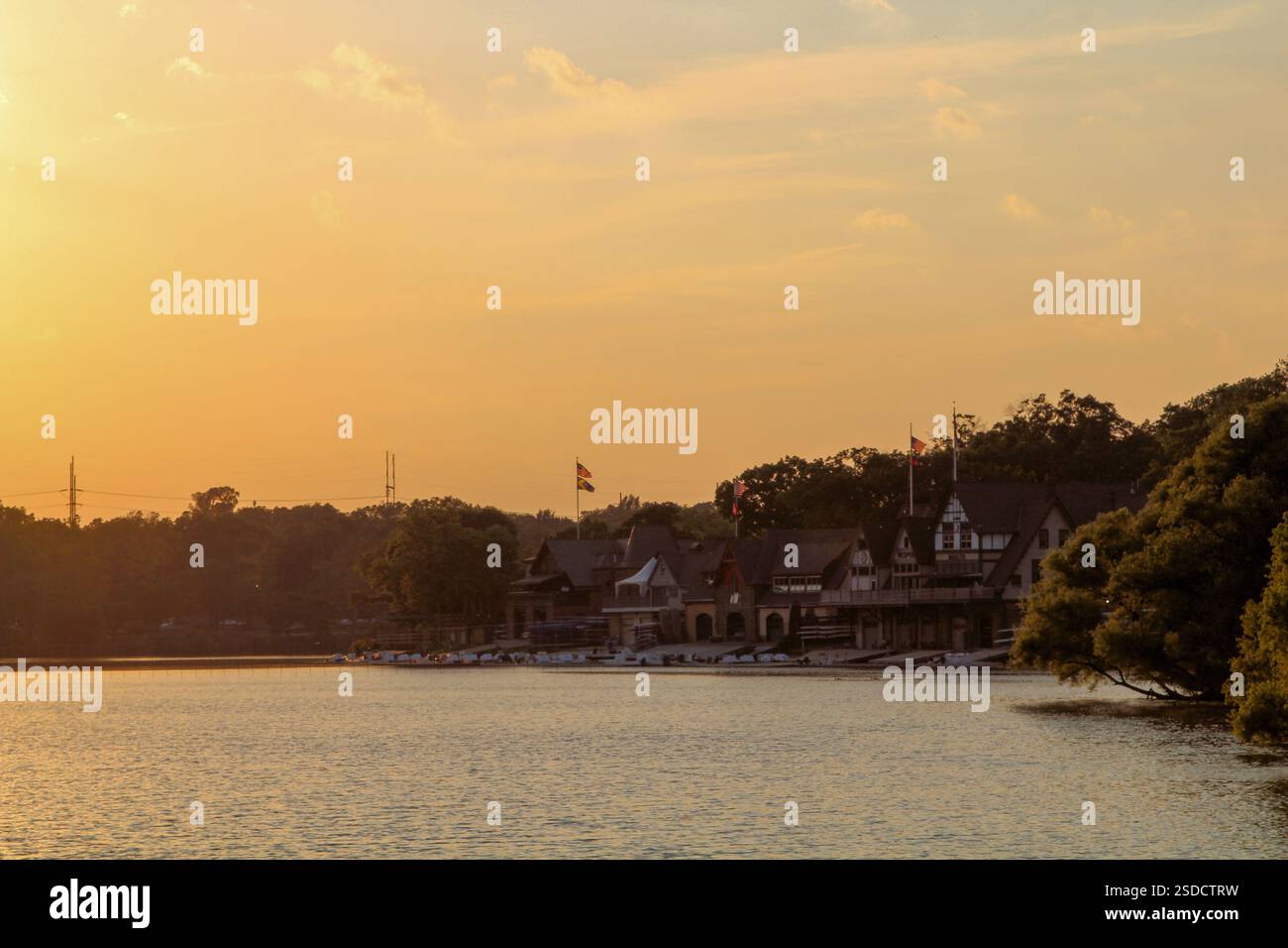 Golden Hour jette une lueur chaude sur le hangar à bateaux au bord du lac. Banque D'Images
