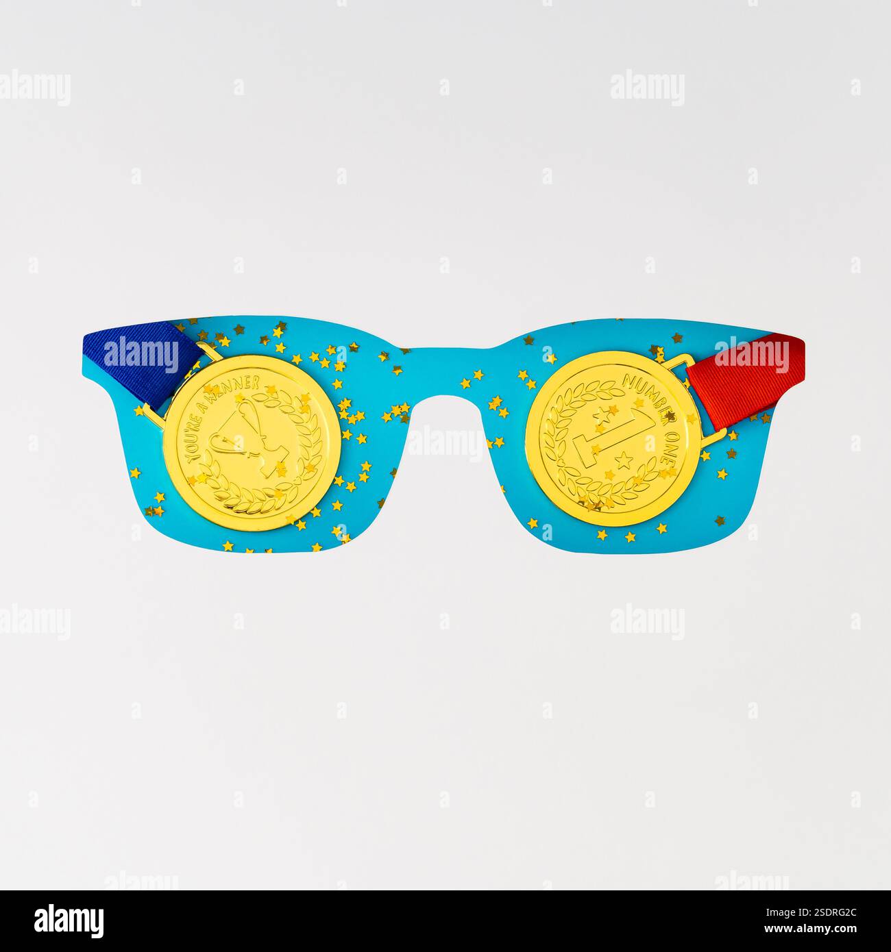 Scintille fond bleu vif avec des médailles dorées visibles à travers des lunettes blanches en forme de découpe. Concept des gagnants minimaux. Vue de dessus, à plat. Banque D'Images