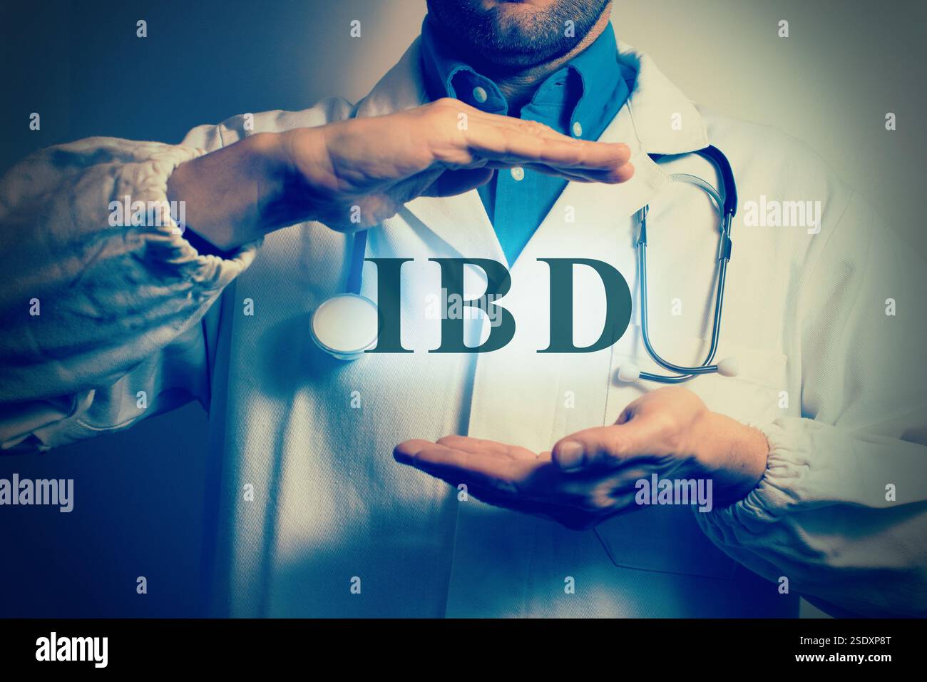 Vue rognée d'un jeune médecin masculin en manteau blanc pointant le doigt vers le haut sur les lettres 'IBD'. Concept médical. Banque D'Images