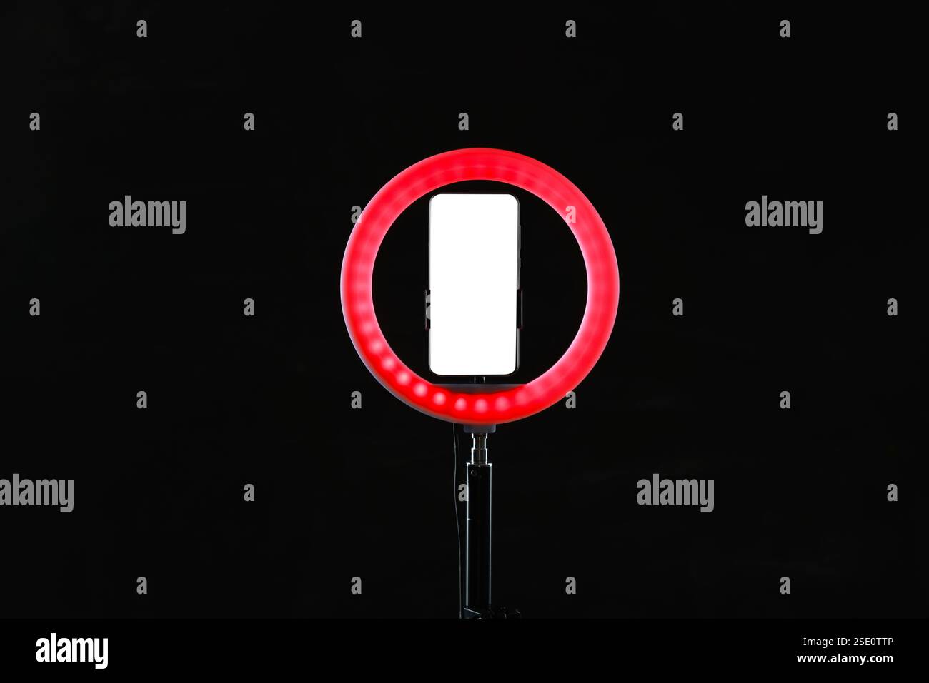 Lampe annulaire avec smartphone sur fond noir Banque D'Images