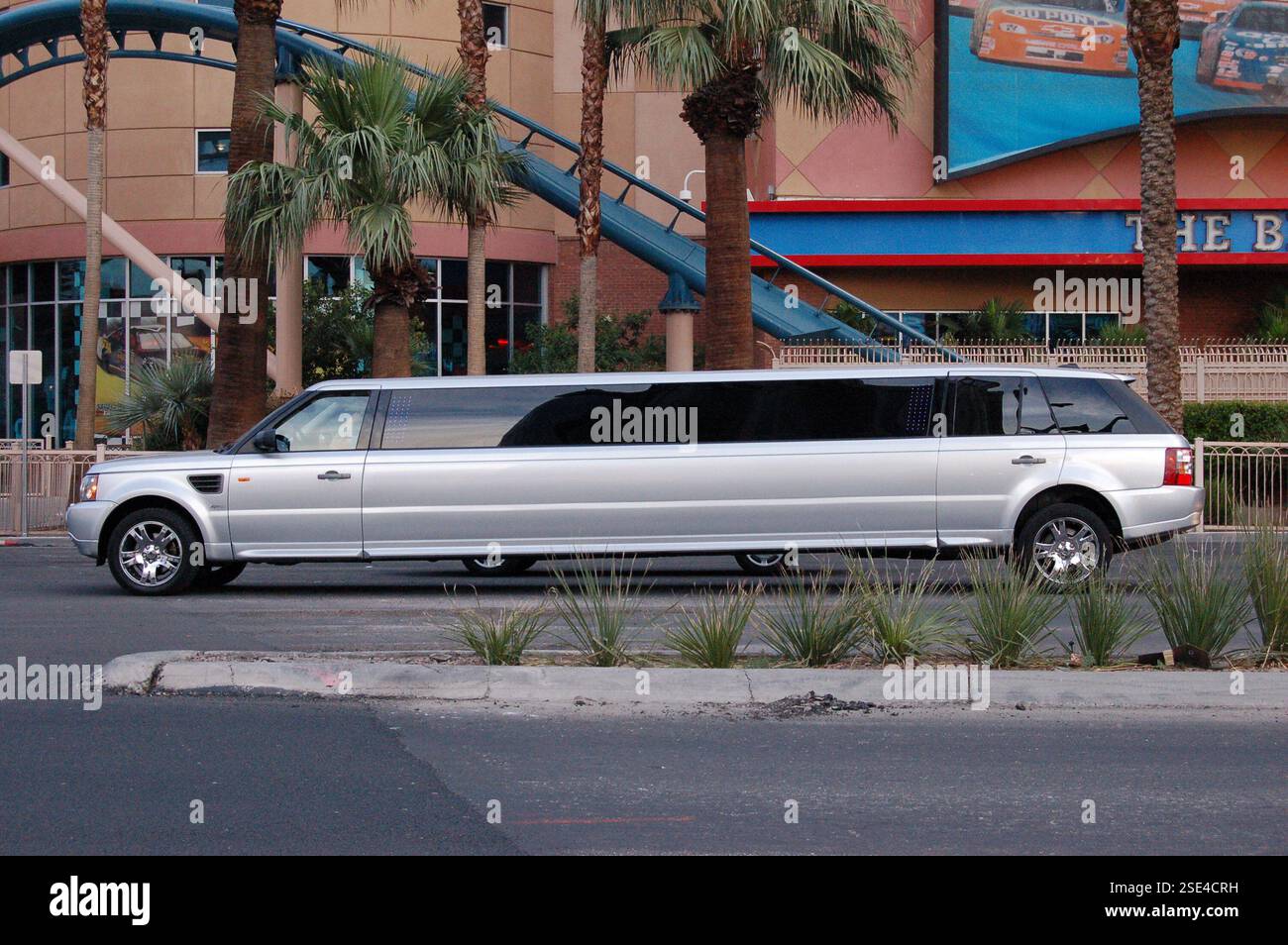 Limousine extensible argentée élégante avec des fenêtres teintées foncées naviguant le long de l'emblématique Strip de Las Vegas, capturant le luxe et l'énergie vibrante de la ville Banque D'Images