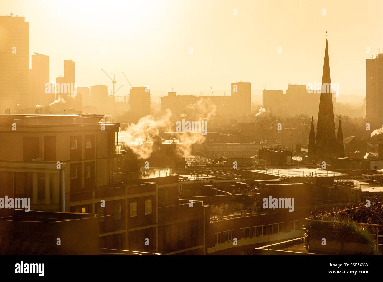 La flèche de l'église St Stephen, Rochester Row et les immeubles de bureaux modernes à Westminster, Londres avec la vapeur qui monte des bâtiments à l'aube en hiver Banque D'Images