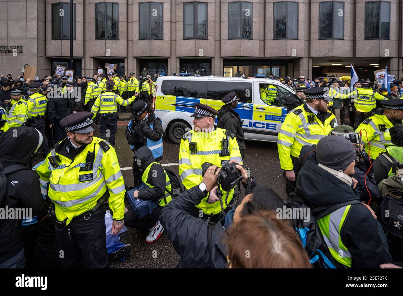 Londres, Royaume-Uni. 8 février 2025. La police gère les manifestants avec des pancartes devant la Royal Mint court, près de la Tour de Londres, s’opposant à la proposition de nouvelle « super-ambassade » de la Chine, qui serait la plus grande ambassade d’Europe. Une enquête locale débutera la semaine prochaine et la décision finale reviendra à Angela Rayner, vice-première ministre et secrétaire au logement. Les résidents locaux et les groupes de campagne représentant les Ouïghours, les Tibétains, les Hongkongais et les dissidents chinois s'opposent à la proposition. Credit : Stephen Chung / Alamy Live News Banque D'Images