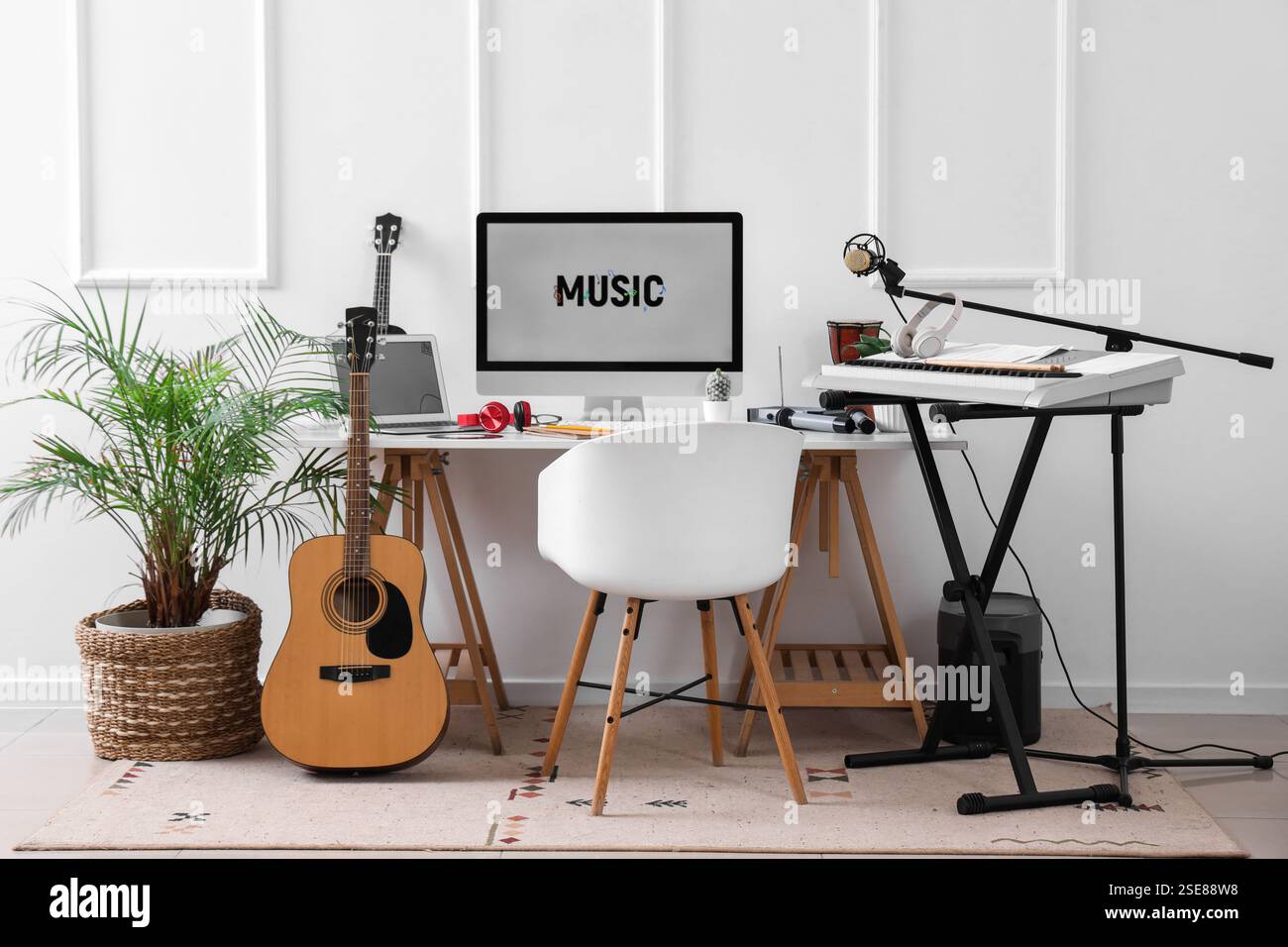 Lieu de travail avec ordinateur et instruments de musique près du mur de lumière dans le studio Banque D'Images