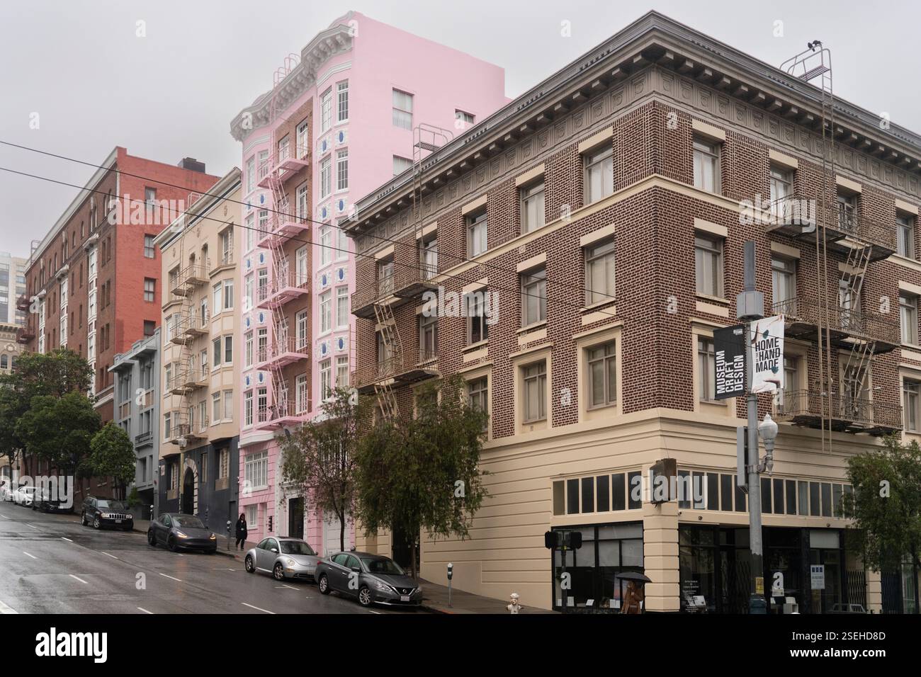 Voitures garées dans une rue de San Francisco, près du Museum of Craft & Design, un bâtiment emblématique sur une colline escarpée. Banque D'Images